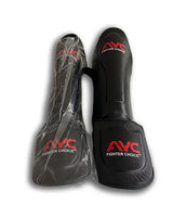 Black martial arts shin guards with red AYC Fighter Choice logo, one wrapped in plastic