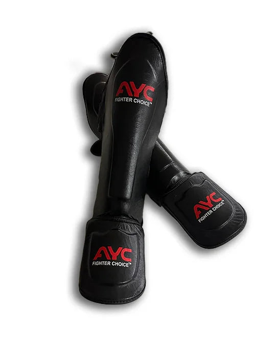 Black martial arts shin guards with red AYC Fighter Choice logo on a white background